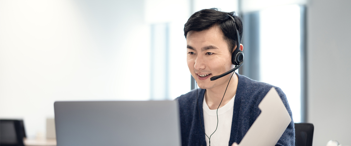 Man wearing headset looking at laptop