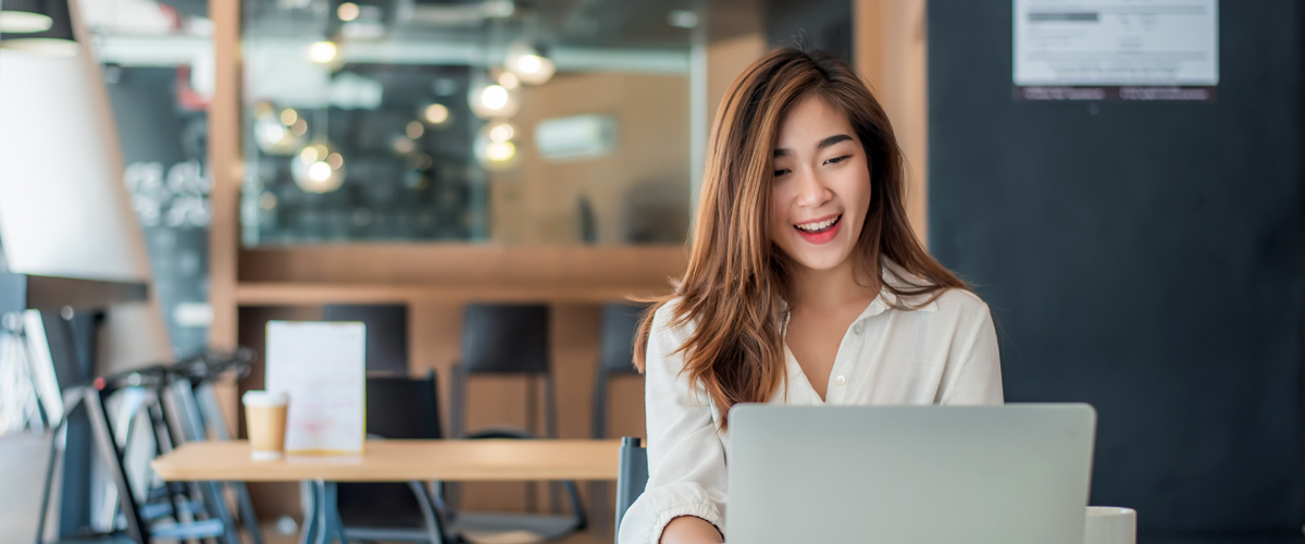 Woman working on laptop at coffee shop