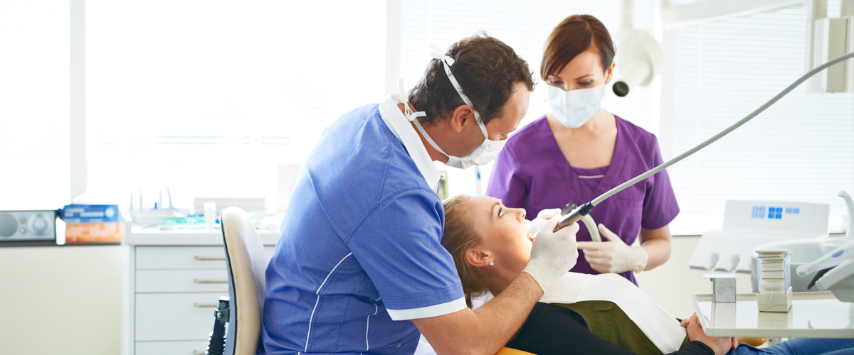 Dentist cleaning woman's teeth